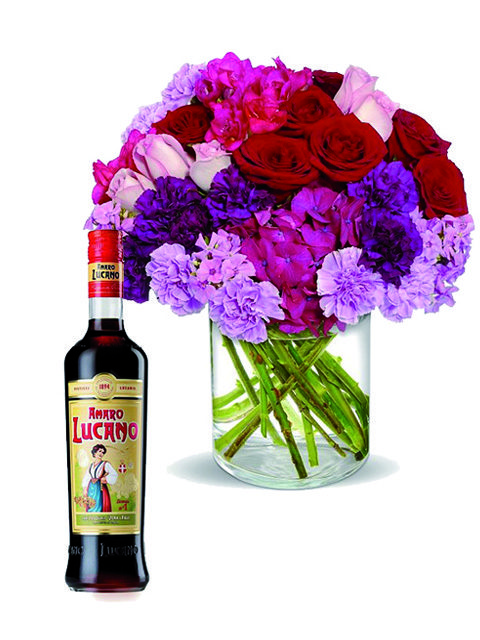 rose e fiori fucsia con bottiglia di amaro